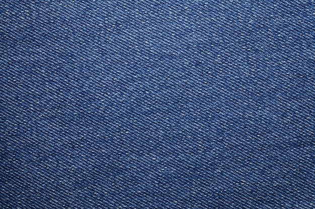 De blauwe gescheurde textuur van denimjeans.