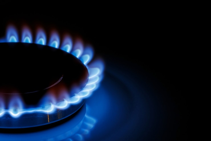 Foto de blauwe vlam van de gasbrander van het keukenfornuis in het donker. plaats onder de tekst.