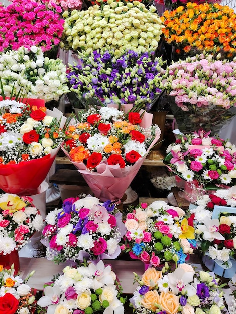 De bloemenwinkel heeft rijen van verschillende boeketten met heldere bloemen te koop