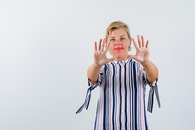 De blonde vrouw toont haar handenvol op een witte achtergrond