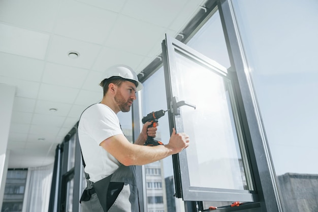 De boor gebruiken Reparateur werkt binnenshuis in de moderne kamer