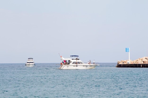 De boot vaart naar de pier Het jacht is ver op zee Witte boot en jachthaven