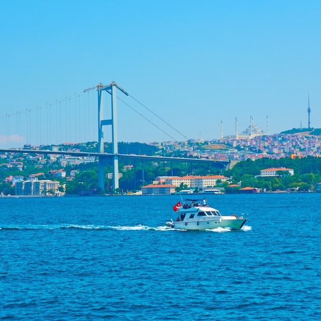 De Bosporus-brug (15 juli Martyrs Bridge) en motorboot in Istanbul, Turkije