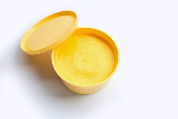 De boter van de margarinekaas op witte oppervlakte