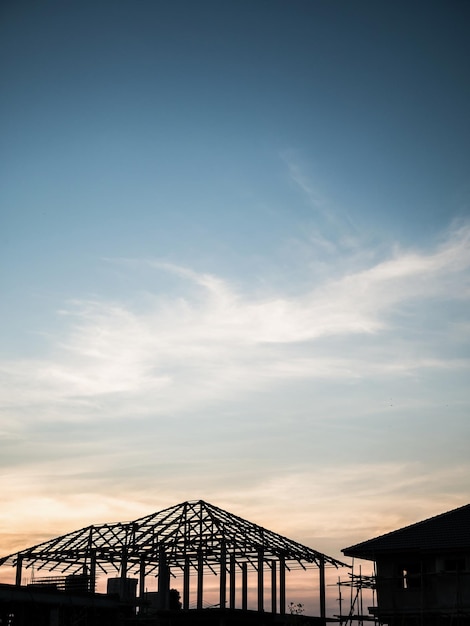 De bouw van het silhouethuis bij de achtergrond van de bouwwerfzonsondergang