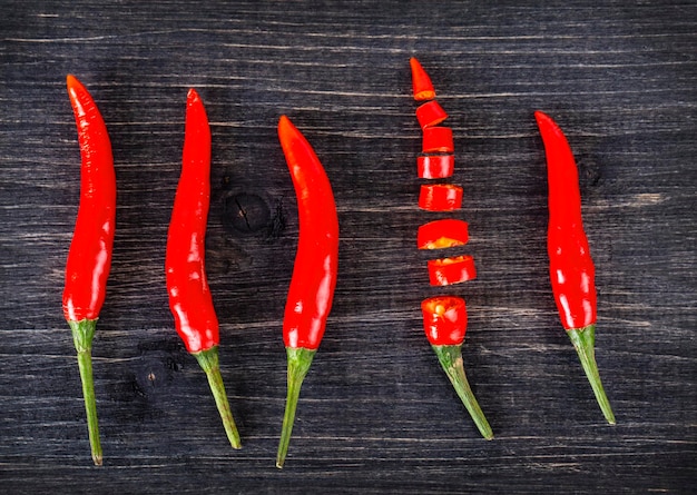 Foto de bovenste weergave van pittige rode chili peper op houten oppervlak selectieve focus