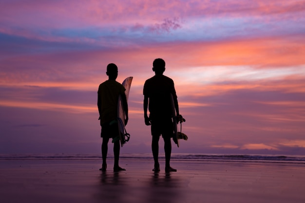 De brandingatleet van het silhouet tijdens zonsondergangtijd in Phuket Thailand