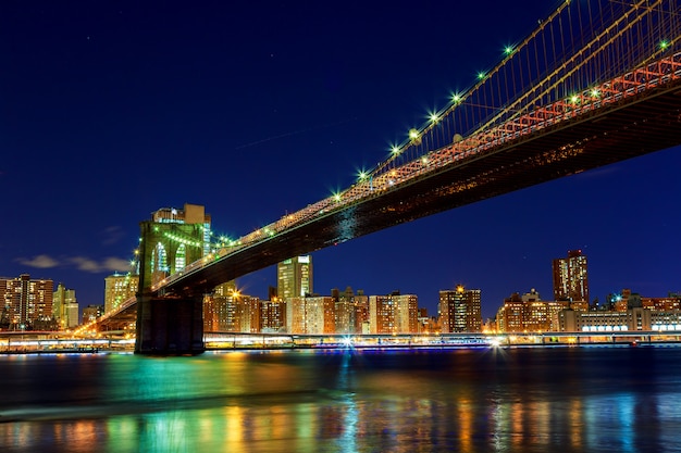 De Brug van Brooklyn over de Rivier van het Oosten bij nacht in de Stad Manhattan van New York