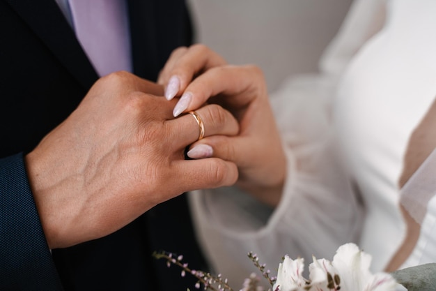 De bruid doet de ring om aan de close-up van het horizontale frame van de bruidegom