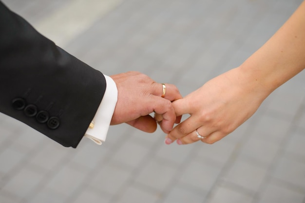 De bruid en bruidegom houden elkaars hand vast