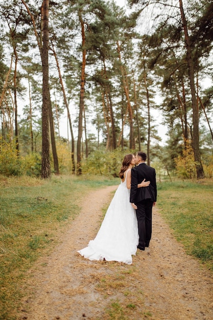 De bruid en bruidegom rennen door een bos Trouwfotoshoot