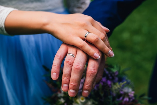 De bruid en de bruidegom van handenjonggehuwden met ringen bij huwelijk