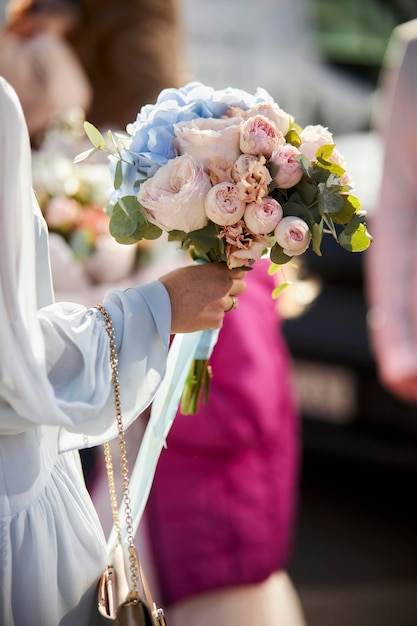 de bruid houdt een bruidsboeket bloemen vast tijdens de ceremonie. de bruid heeft een boeket in handen