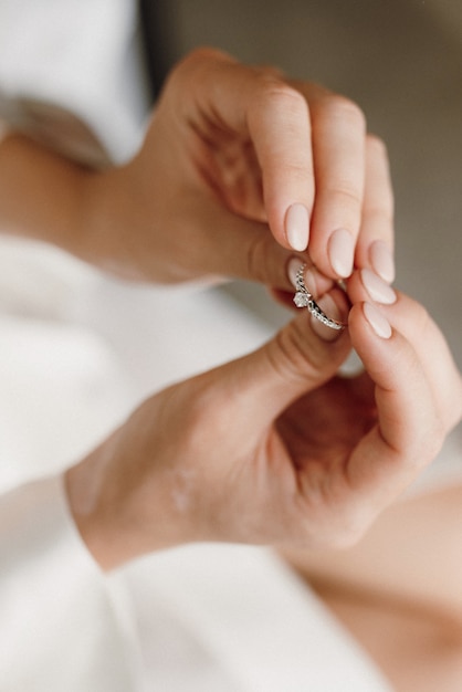 De bruid houdt een verlovingsring met edelstenen in haar handen