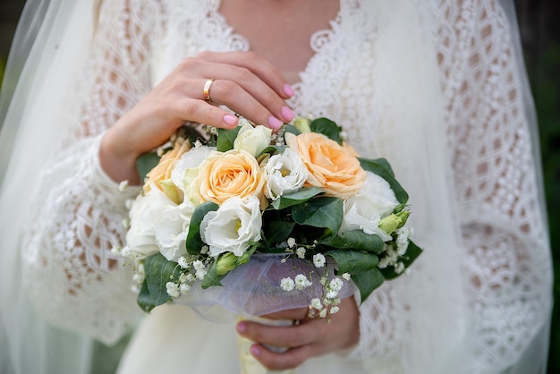 De bruid in een witte jurk heeft een boeket bloemen in haar handen, een idee voor bureaus voor huwelijksevenementen