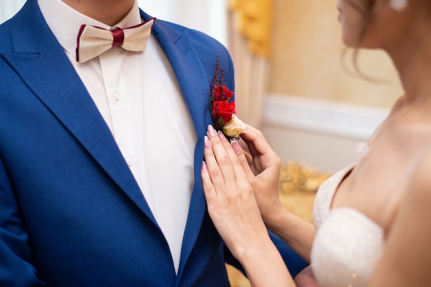 De bruid trekt een roze corsage recht naar haar vrouw