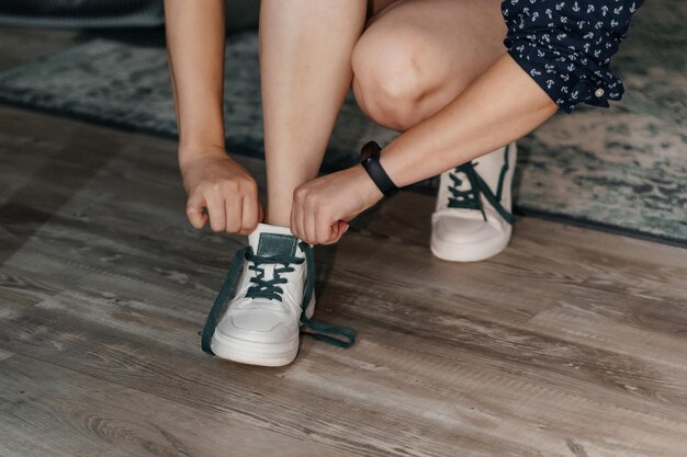 De bruid trekt witte sneakers aan met groene veters