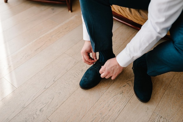 De bruidegom 's ochtends voor de huwelijksceremonie draagt schoenen Zakenman bindt de veters aan de schoenen Herenstijl Beroepen Ter voorbereiding op het werk naar de vergadering Bovenaanzicht