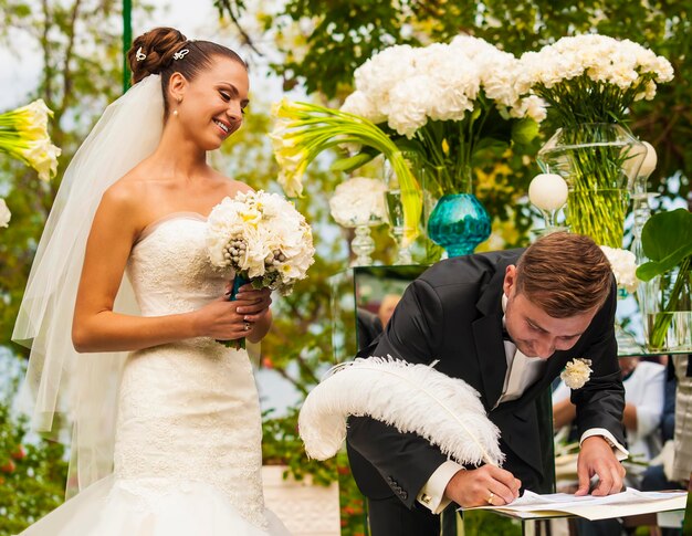 De bruidegom zet zijn handtekening.