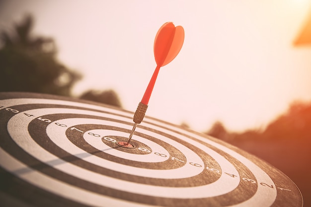 De bullseye, of bull's eye of dartbord heeft een dartpijl die het midden van een schietdoel raakt voor zakelijke targeting en goed succes.