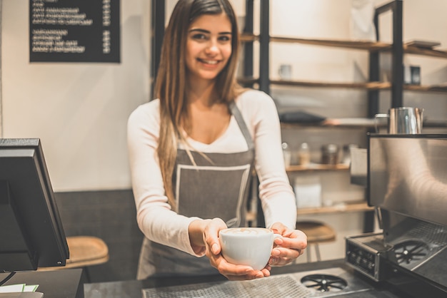 De cafémedewerker met een kopje koffie