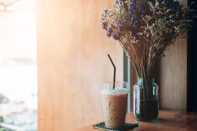 De cameraclose-up heeft een goede dag met een kop van koffie en plant pottenachtergrond met zonlicht