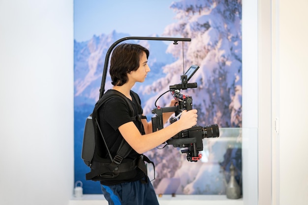 De cameraman maakt foto's en neemt video's op die tienerjongen leert