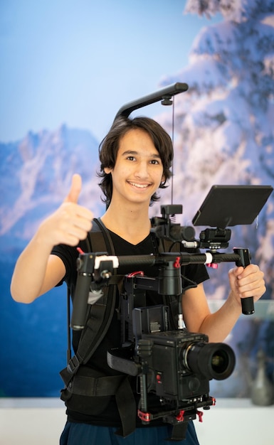 De cameraman maakt foto's en neemt video's op die tienerjongen leert