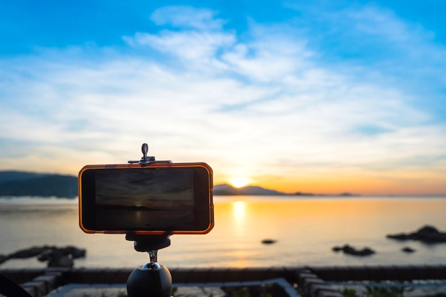 De cameratribune van Smartphone op statief fotograferen toneel van avondzonsondergang