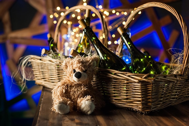 De champagnefles van de teddybeer met gouden slingers van de Kerstmismand op donkerbruine houten achtergrond nieuwe jaarviering conceptxA