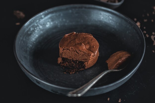 De cheesecake van de chocolademuffin op donkere plaat met vork