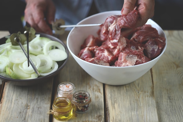 De chef bereidt vlees voor op de barbecue Stukjes vlees in een kom