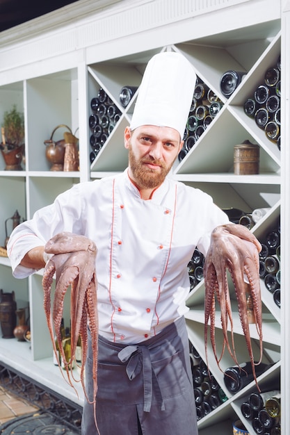 De chef houdt een octopus vast.