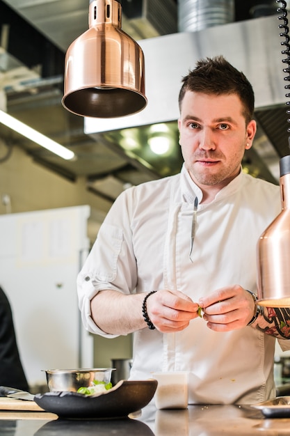 De chef-kok bereidt het haasbiefstuk van het rundvleeslapje vlees in de restaurantkeuken