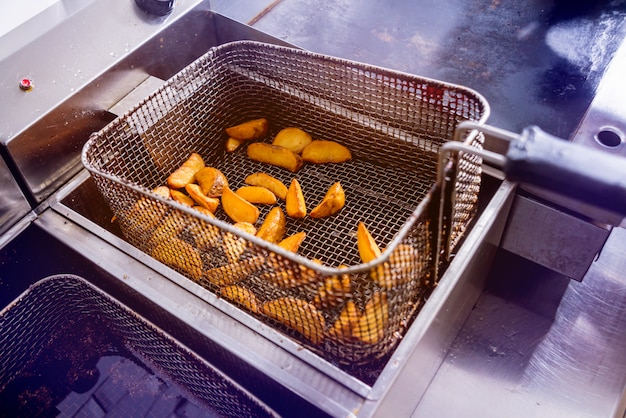 Foto de chef-kok die frieten kookt.