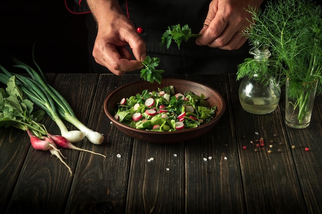 De chef maakt een salade van verse groenten