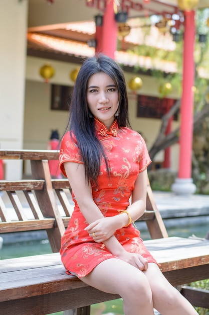 De Chinese vrouw kleedt traditionele cheongsam bij Nieuwjaar