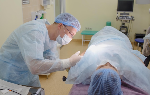 De chirurg injecteert het medicijn bij de patiënt die op de operatietafel ligt