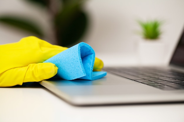 De close-up van een schoonmakende bedrijfarbeider maakt bureau schoon