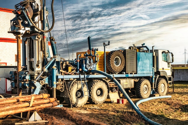 De close-up van het booreiland boort een put tegen de achtergrond van de bewolkte hemel Diepe gaten boren Geologische exploratiewerkzaamheden minerale exploratie Winning van gas en olie