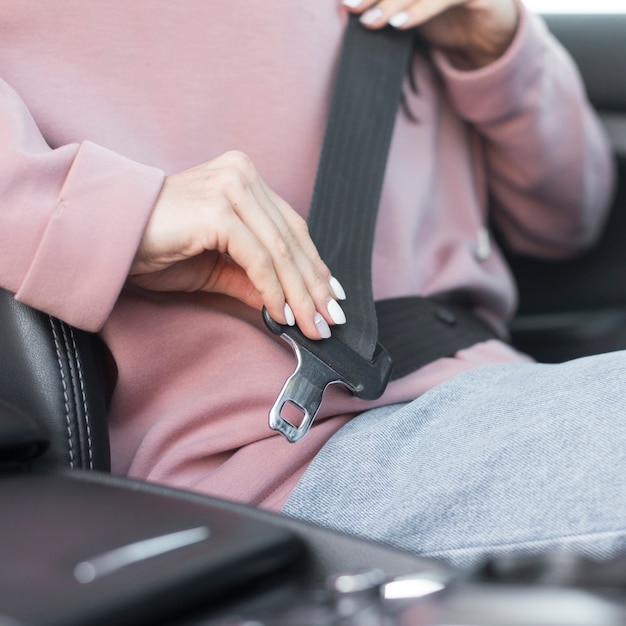 Foto de close-upvrouw zet haar veiligheidsgordel