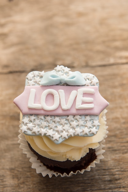 De cupcake met het woord love op een bruine achtergrond. Valentijnsdag