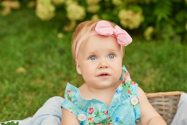 De dag van de kinderenbescherming, babymeisje in het park zit in een mand op een de zomerpicknick