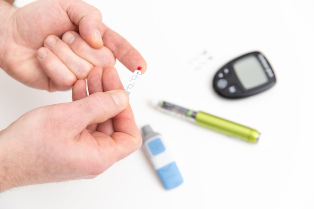 De diabeet meet het glucosegehalte in het bloed en maakt een bloedsuikertest in de kliniek