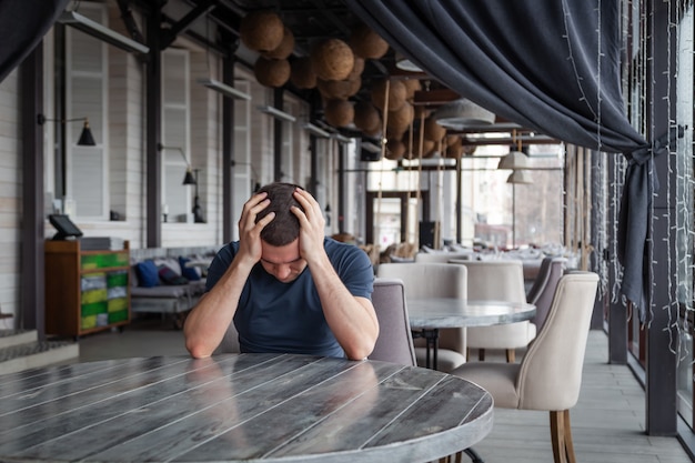 De directeur van het restaurant van de man houdt zijn hoofd vast, voelt zich bezorgd en depressief