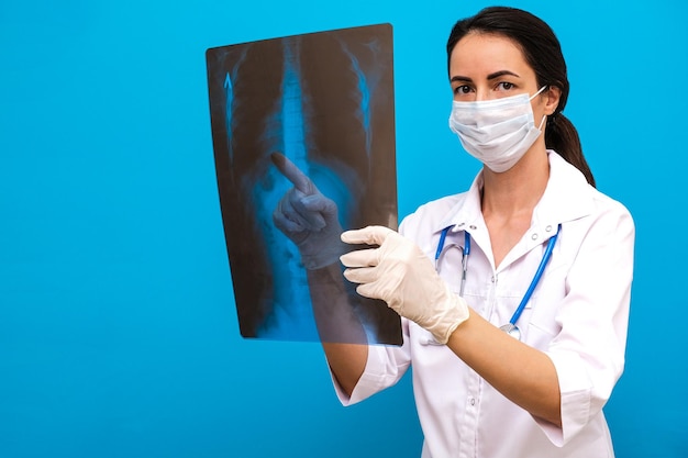 De dokter houdt een röntgenfoto van de wervelkolom in zijn handen