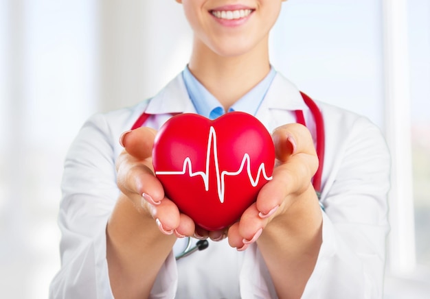 Foto de dokter houdt en toont een rood hart concept voor onderwerpen gezondheidsondersteuning