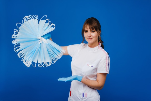 De dokter houdt veel medische maskers bij elkaar.