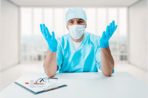 De dokter in de kliniek kijkt vragend naar de camera. Geneeskunde concept.