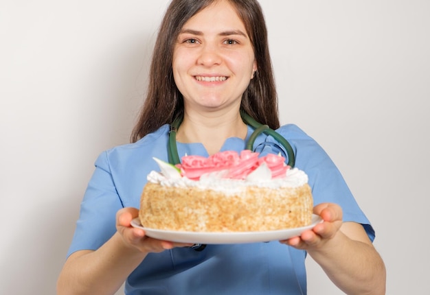 De dokter of verpleegkundige houdt een grote verjaardagstaart gefeliciteerd met de dag van de dokter of verpleegkundige